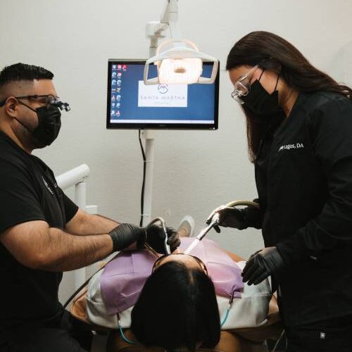 A dr and Dental Assistant doing some routine dental checkup on a patient A dr and Dental Assistant doing some routine dental checkup on a patient